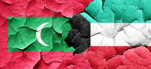 Maldives flag with Kuwait flag on a grunge cracked wall