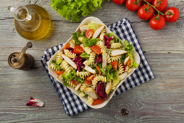 Noodle salad with green salad, tomatoes and roasted chicken.