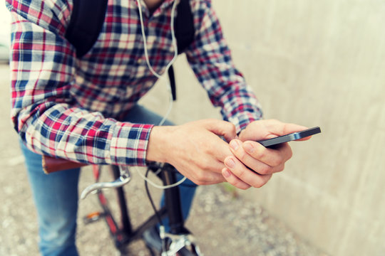 hipster man in earphones with smartphone and bike
