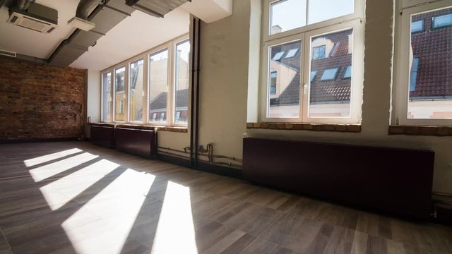 Time-lapse of sun rays moving over an empty rustic office space
