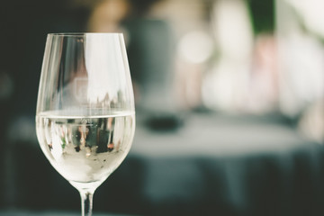 Weinglas mit Weißwein, Hintergrund unscharf - obrazy, fototapety, plakaty