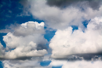 White fluffy storm clouds in blue sky