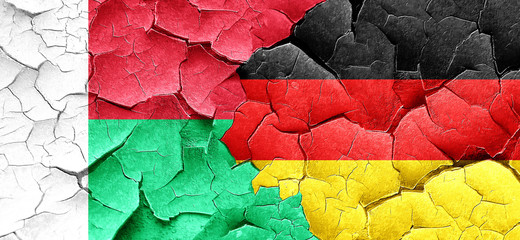 Madagascar flag with Germany flag on a grunge cracked wall