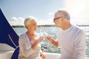 senior couple clinking glasses on boat or yacht
