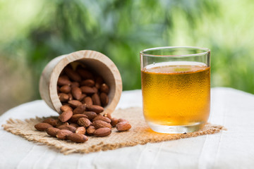 Cup of green tea with almonds placed close together.