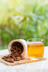 Cup of green tea with almonds placed close together.
