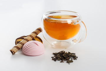 Double sided wall glass cup full of green tea with sweets and biscuits