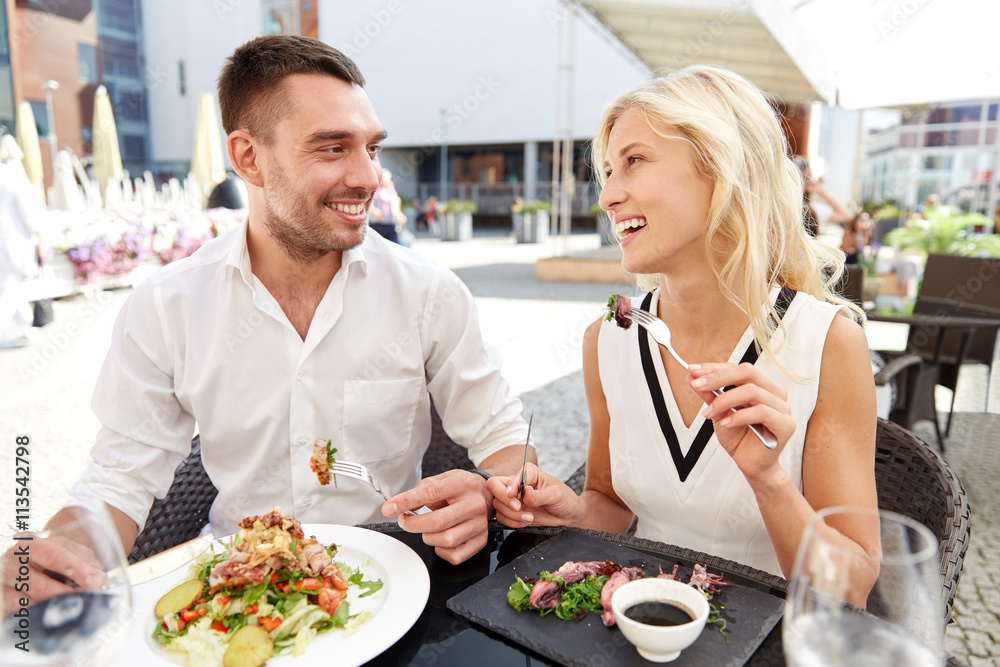 Wall mural happy couple eating dinner at restaurant terrace