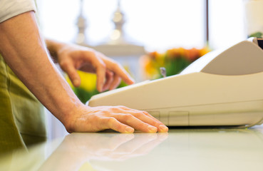 Fototapeta premium close up of man or seller at flower shop cashbox