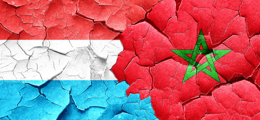 Luxembourg flag with Morocco flag on a grunge cracked wall