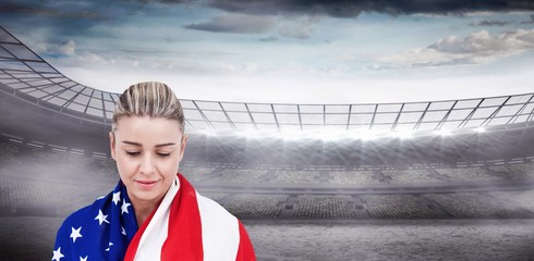 Female athlete with american flag on her shoulders against rugby stadium