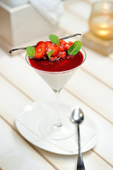 Vanilla panna cotta with strawberry sauce and mint, vertical