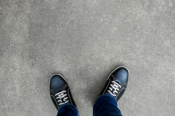 Black casual shoes standing on concrete floor - Powered by Adobe