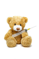 Toy teddy bear with medicine pill isolated on white background
