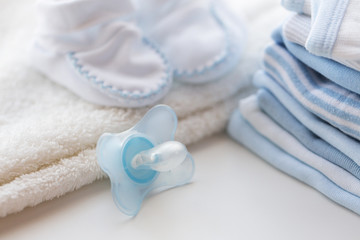 close up of soother and baby clothes for newborn