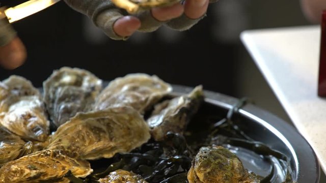 Chef opens oysters for visitors to the restaurant.