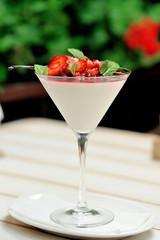 Vanilla panna cotta with strawberry sauce and mint, vertical