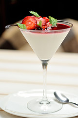 Vanilla panna cotta with strawberry sauce and mint, vertical