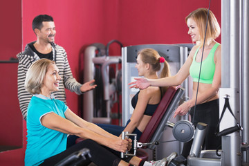 Fototapeta premium Active glad people weightlifting training in health club