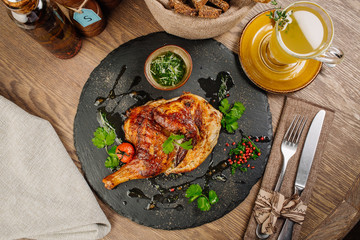 chicken Tabaka with sauce on stone plate.
