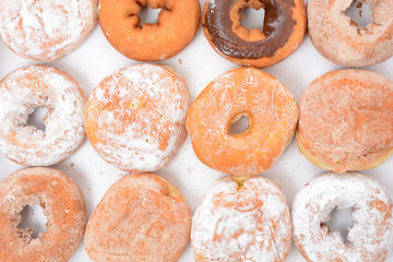 powder and chocolate donuts in a row 