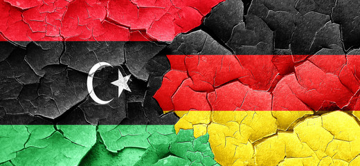 Libya flag with Germany flag on a grunge cracked wall