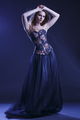 Portrait of a woman in a beautiful dress with a floral pattern in the Studio