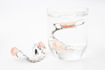 removable partial denture is cleaned in a glass of water. proper