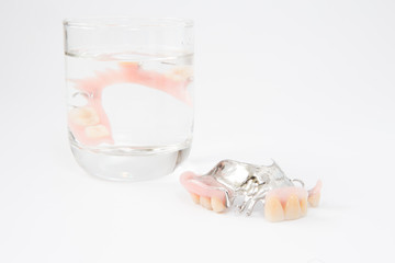 removable partial denture is cleaned in a glass of water. proper