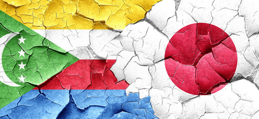 Comoros flag with Japan flag on a grunge cracked wall