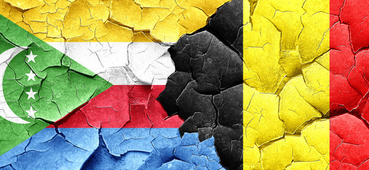 Comoros flag with Belgium flag on a grunge cracked wall