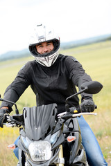 handsome young man biker with white helmet riding black motorcycle