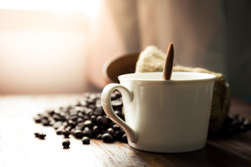 White cup place beside the coffee bean on the table