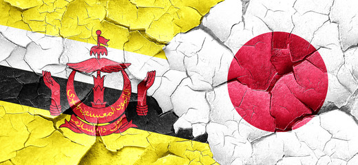 Brunei flag with Japan flag on a grunge cracked wall