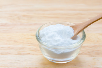 Fototapeta na wymiar Baking soda (Sodiumbicarbonate) on wooden table 