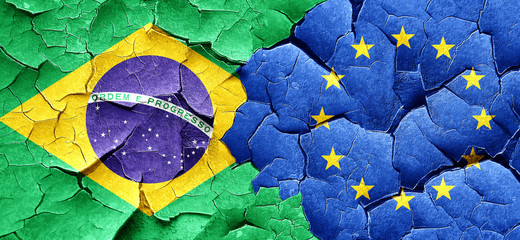 Brasil flag with european union flag on a grunge cracked wall