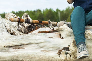 girl sitting on a log with his legs dangling . девушка сидит на бревне свесив ноги