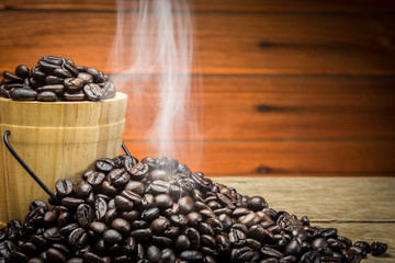 Hot roasted coffee beans on a wooden background.
