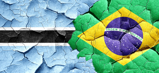 Botswana flag with Brazil flag on a grunge cracked wall