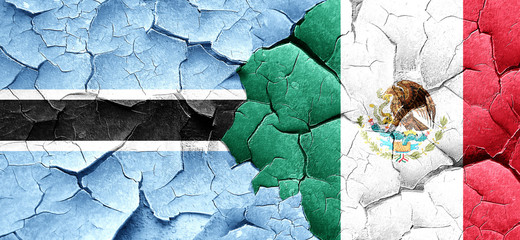 Botswana flag with Mexico flag on a grunge cracked wall