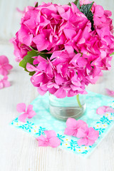 hydrangea flower in vase on wooden surface