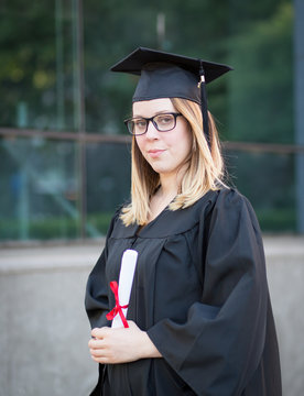 Portrait of female college student with glasses in graduation da