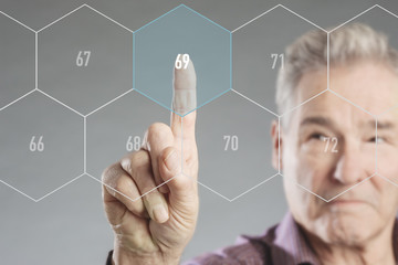 Senior Mann wählt Rentenalter auf einem futuristischen virtuellen digitalen Bildschirm