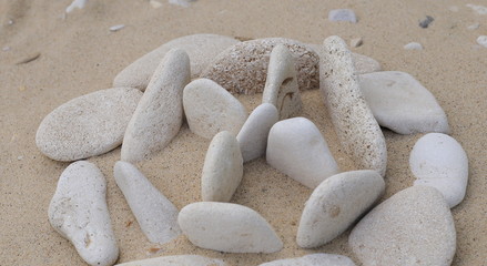 Fototapeta na wymiar Stones pebbles of different color and size of the sand in the form of symbols and figures 