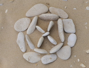 Stones pebbles of different color and size of the sand in the form of symbols and figures

