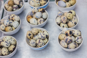 quail eggs in a bowl on a wooden table