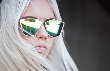 Beautiful blonde girl in green sunglassses outdoor
