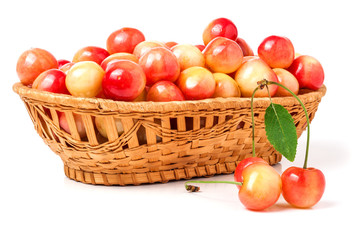 yellow cherries in a wicker basket isolated on white background