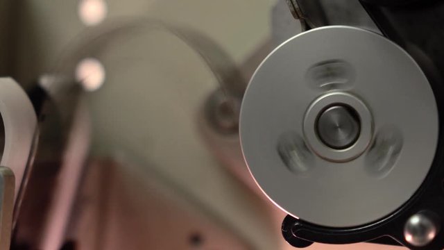 Rotating spool in professional film cinema projector, 4K video, part of set