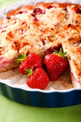 Three strawberries in blue bowl with fruit cake